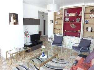 uma sala de estar com um sofá e uma mesa em Le Tanagra em Vallauris