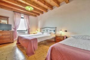 a bedroom with two beds and a flat screen tv at Casa Romantica La Parenzana in Buje