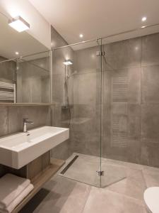 een badkamer met een wastafel en een glazen douche bij DECK 8 BOARDINGHOUSE.SOEST in Soest