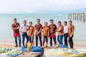 a group of people standing on the beach at Enjoy Beach in Bophut