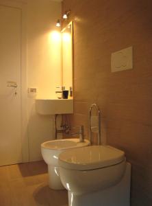 ein Badezimmer mit einem WC, einem Waschbecken und einem Spiegel in der Unterkunft Rinathos Guesthouse in Arezzo