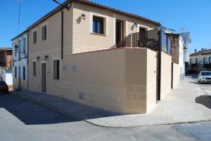 un edificio con una valla al lado de una calle en Apartamentos Rurales el Trillo, en Malpartida de Plasencia