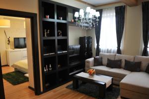a living room with a couch and a television at Luxury Apartment in Braşov