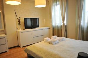 a bedroom with a bed with towels and a flat screen tv at Luxury Apartment in Braşov
