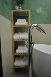 a bathroom with a towel rack with towels and a tub at Luxury Apartment in Braşov