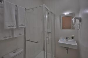 a white bathroom with a shower and a sink at Porto Charming Hotel in Porto +57 photos