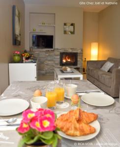 une table recouverte de assiettes de nourriture et de jus d'orange dans l'établissement Gite Joël et Nathalie, à Urschenheim