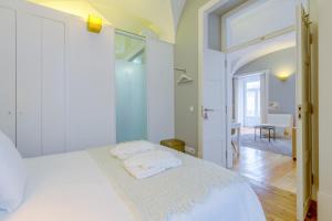 a bedroom with a white bed with towels on it at Sonel Investe Figueira Boutique Apartment by Get Your Stay in Lisbon