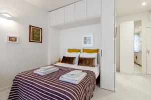 a white bedroom with a large bed with towels on it at Formosa Flats in Porto