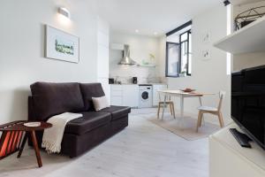 uma sala de estar com um sofá castanho e uma mesa em Formosa Flats no Porto