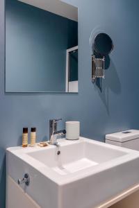 a bathroom with a white sink and a mirror at Formosa Flats in Porto