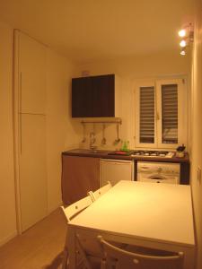 eine Küche mit einem weißen Tisch und einer Arbeitsplatte in der Unterkunft Rinathos Guesthouse in Arezzo