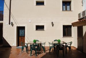 a patio with a table and chairs and a building at Apartamentos Rurales el Trillo in Malpartida de Plasencia