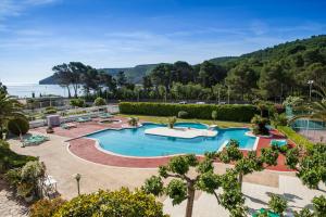 a large swimming pool in a resort with trees at Can Miquel in L'Escala