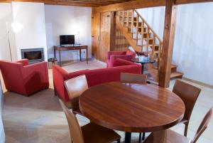 a living room with a table and chairs and a staircase at Casa De Campo De Oliveiras in Penela