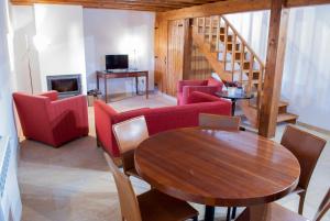 a living room with a table and chairs and a staircase at Casa De Campo De Oliveiras in Penela