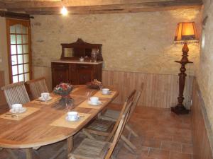 - une table en bois avec des chaises et une lampe dans la chambre dans l'établissement La Ferme du Pech, à Saint-Geniès