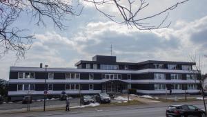 een groot gebouw met auto's geparkeerd op een parkeerplaats bij Snow in Winterberg