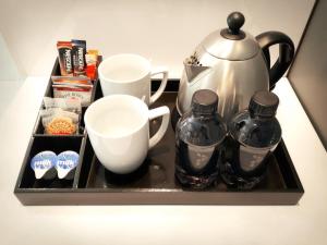 a tray with a tea pot and cups on a counter at Palm Swift Luxury Accommodation in Brits