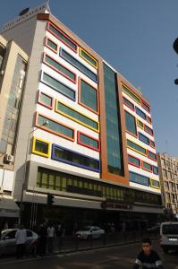 ein hohes Gebäude mit bunten Fenstern auf einer Stadtstraße in der Unterkunft Hotel Senbayrak City in Adana