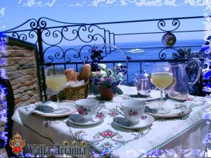 a table with cups and saucers and drinks on it at Villa Arianna B&B in Taormina