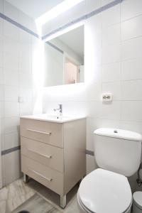 uma casa de banho branca com um WC e um lavatório em Monsalves Courtyard by Valcambre em Sevilha