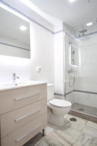 uma casa de banho branca com um WC e um chuveiro em Monsalves Courtyard by Valcambre em Sevilha