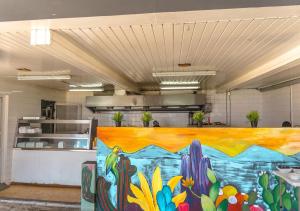a large kitchen with a large painting on the wall at Curacao Airport Hotel in Willemstad