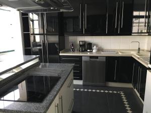 a black and white kitchen with black cabinets at Casa da Nova Ponte in Tavira +21 photos