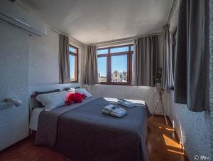 ein Schlafzimmer mit einem Bett mit einer blauen Decke und einem Fenster in der Unterkunft La Torretta dei Merli with Views in Vernazza