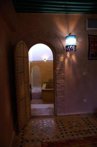 Un arco que conduce a una habitación con bañera en Riad Felloussia en Meknès