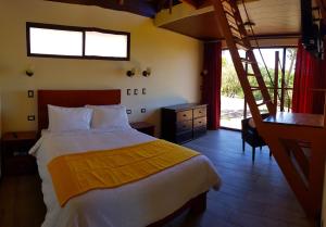 um quarto com uma cama grande e uma escada em Green Forest Rustic Houses em Monteverde