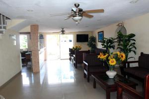 a living room with couches and a ceiling fan at Hotel Barracuda in Cozumel