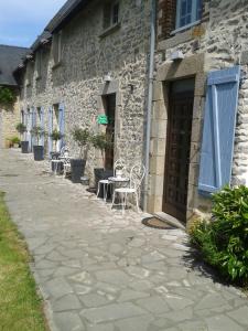 a stone building with tables and chairs outside of it at La Jumelière Laval Nord in Changé