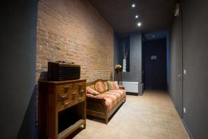 un soggiorno con divano e muro di mattoni di Camere Centro Storico a Canelli
