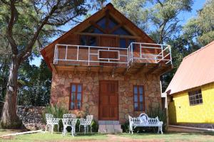 a house with a balcony on top of it at Cabañas Cumbres de Aguacatitla in Huasca de Ocampo