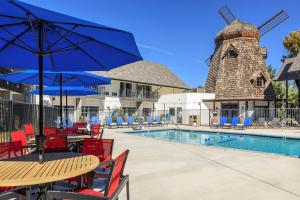 a pool with tables and chairs and a windmill at Sideways Inn in Buellton