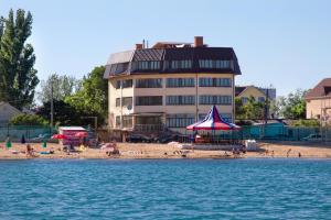 a beach with people on the sand and a building at Mileta Hotel in Feodosia