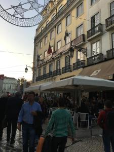 um grupo de pessoas andando por uma rua perto de um edifício em Lisbon Fragrances em Lisboa