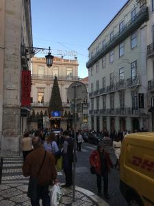 uma multidão de pessoas andando por uma rua com uma árvore de Natal em Lisbon Fragrances em Lisboa