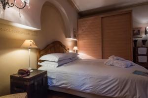 sypialnia z dużym łóżkiem z białą pościelą i poduszkami w obiekcie Anerada inn Suites & Spa - Pet Friendly w mieście Karpenision