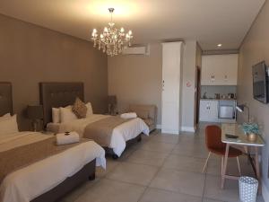 Pokój hotelowy z 2 łóżkami i żyrandolem w obiekcie Suikerbossie Guesthouse w mieście Bloemfontein
