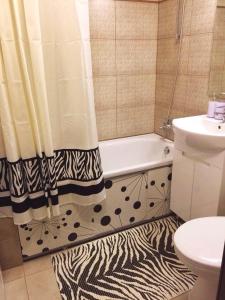 a bathroom with a zebra shower curtain and a bath tub at Двухкімнатна студія in Chernihiv