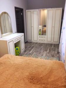 a bedroom with white cabinets and a large mirror at Двухкімнатна студія in Chernihiv