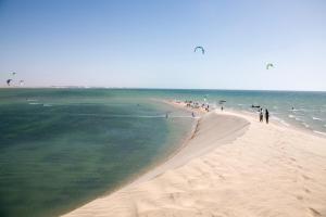 un gruppo di persone su una spiaggia con persone che volano aquiloni di Résidence Tamaya a Dakhla