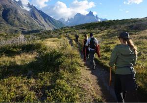 a group of people walking down a mountain trail at Hostal Boutique Factoria Patagonia in Puerto Natales