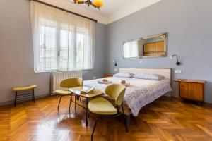 a bedroom with a bed and a table and chairs at Spacious & Smart Center Apartment in Pula