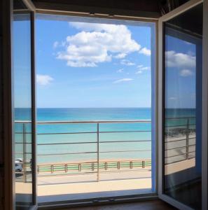 een raam met uitzicht op het strand bij Central Rooms in Noto Marina