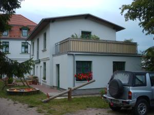 a white house with a car parked in front of it at Ferienhaus Schwalbe Seebad Lubmin in Lubmin