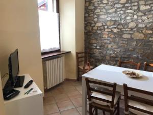 une salle à manger avec une table blanche et un mur en pierre dans l'établissement casa vacanze il gelsomino, à Nocera Umbra
